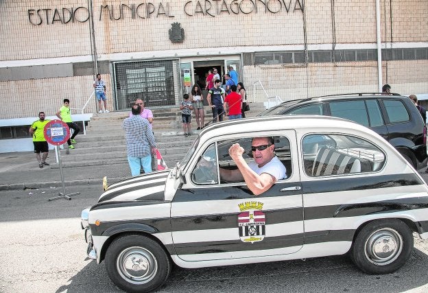 Paco 'El del 600' pasando por la puerta del Cartagonova, con aficionados esperando para comprar entradas, ayer./J. M. Rodríguez / AGM