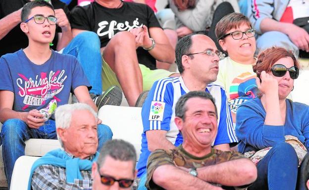 Un aficionado del Recreativo, ajeno a los hechos, siguiendo el partido del pasado sábado rodeado de seguidores del Cartagena.