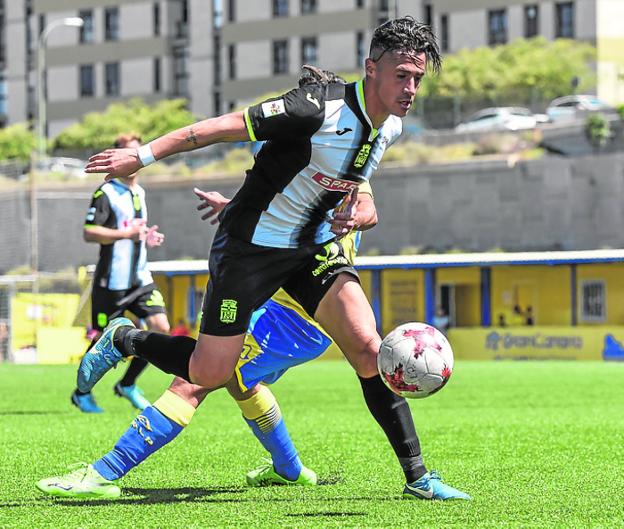Hugo Rodríguez se marcha de un rival y centra en el último partido que jugó, ante el filial de Las Palmas. / LOF