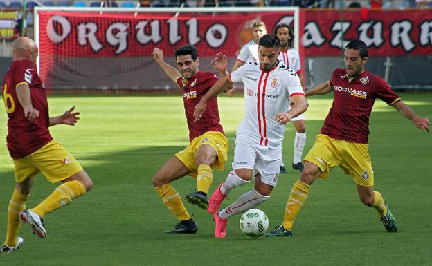 David Forniés conduciendo el balón rodeado de adversarios.