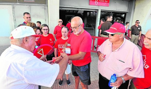 Pepe Almansa, en el centro, vendiendo bolígrafos antes del choque entre el Murcia y el Écija.