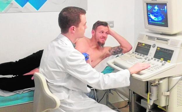 Charlie Dean, ayer, junto al cardiólogo Juan Sánchez en la Clínica Cardiosalus, durante su reconocimiento./La Verdad