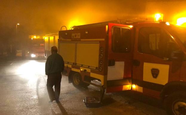 El dueño de la vivienda, junto a un camión de bomberos durante el incendio. /LV