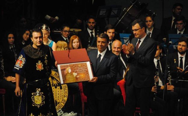 Alfonso de la Cruz muestra el obsequio de la Federación de Moros y Cristianos de Murcia; el alcalde José Ballesta se suma a la ovación que recibió de todo el teatro.