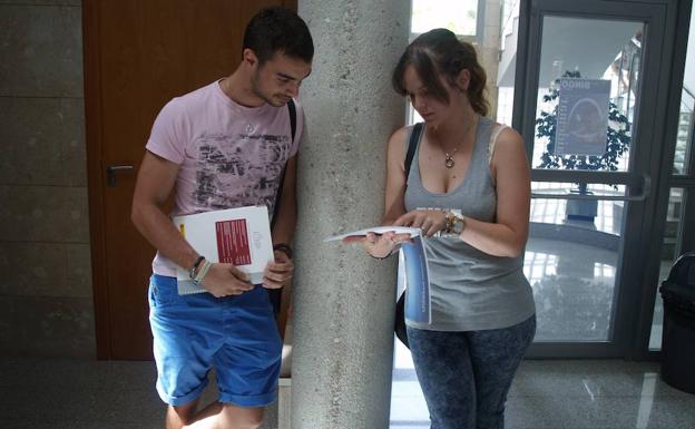 Dos alumnos de secundaria repasan uno de sus libros de texto antes de un exámen.