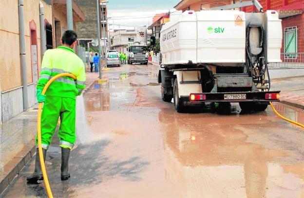 Un operario limpia las calles con una manguera tras las últimas lluvias./S. Sánchez