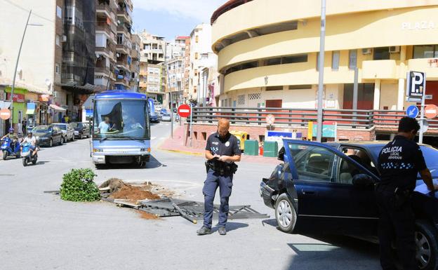 Dos agentes evalúan los daños provocados por el autobús.