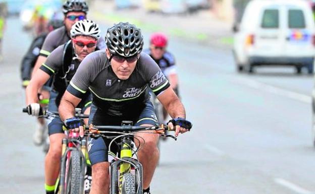 Arriba, ciclistas circulando por una de las rutas seguras de la Región. A la izquierda, una de las señales indicativas que, según anunció la DGT, se instalarían en estas vías.