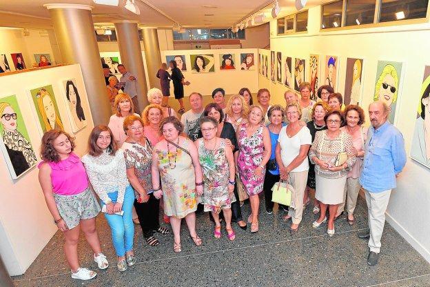 Jiménez Asensio, anoche, con sus alumnas ante algunos de los retratos.