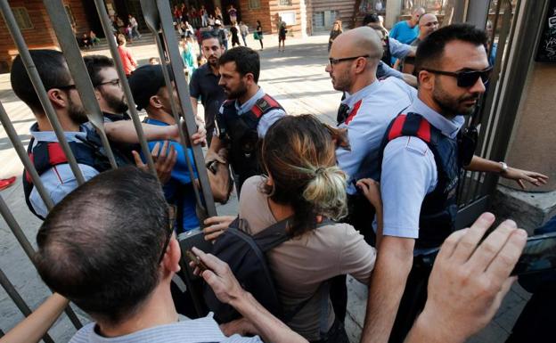 Varias personas tratan de acceder a un colegio electoral en Barcelona./Pau Barrena (Afp)