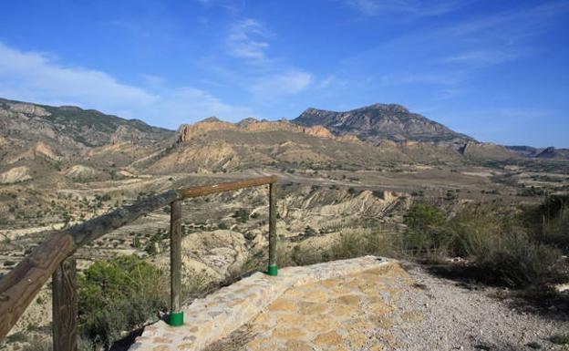 Las crestas rojizas de la Sierra del Águila y la inconfundible silueta de La Pila en forma de silla de montar, desde el mirador de La Loma./