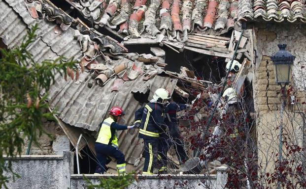 a médico de una ambulancia medicalizada accede, ayudada por un bombero, al interior de la vivienda. /Jesús Diges (Efe)