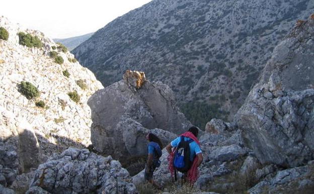 Los escaladores bajan por la senda hasta el camino del valle./