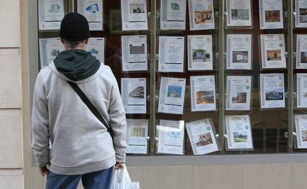 Un hombre observando el escaparate de una inmobiliaria. /JOSÉ MARÍA RODRÍGUEZ / AGM