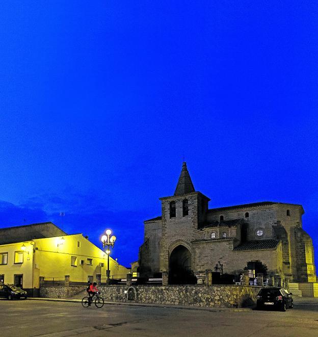 Un ciclista bien abrigado aporta algo de calor a la plaza mayor de Sijena, presidida por la iglesia parroquial de Santo Domingo y El Salvador, del siglo XVI, y que estuvo vinculada a las posesiones del ya célebre monasterio que acaba de recuperar las obras de arte exhibidas en Lérida./Álvaro Calvo