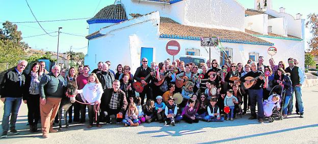 Miembros de la cuadrilla y vecinos de Perín, ante la iglesia del pueblo, el domingo. / J. Lorente