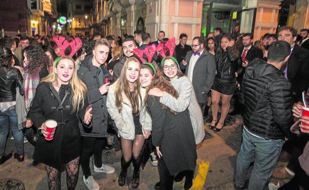 Un grupo de jóvenes, con gorros en forma de cabeza de reno, en la esquina de la calle del Aire con Cuatro Santos./José María Rodríguez / AGM
