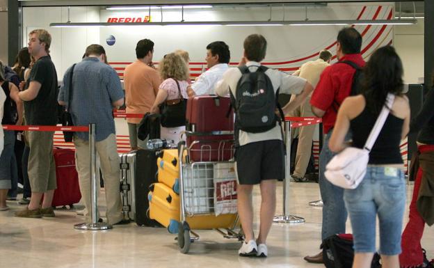Los pasajeros hacen cola frente a un mostrador de atención al cliente, en una fotografía de archivo./EFE