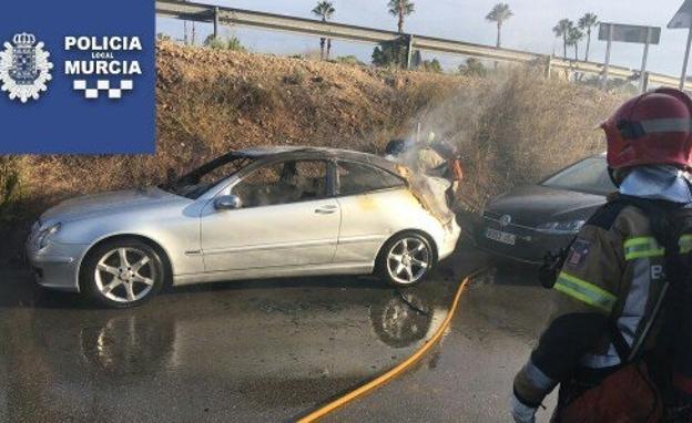 Un bombero observa el coche afectado por las llamas./Policía Local de Murcia