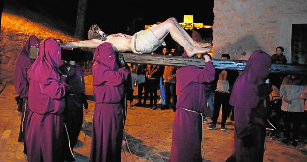 Los Hermanos del Socorro portan a hombros la talla del Cristo de la Misericordia junto a las capillas del Calvario y con el castillo de la ciudad al fondo, anoche./Jaime Insa / AGM