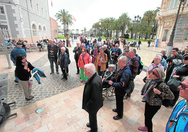 Un grupo de turistas recibe una charla en la puerta del Museo del Teatro Romano, en la Plaza del Ayuntamiento, en la primera doble escala de cruceros del año./Antonio Gil / AGM