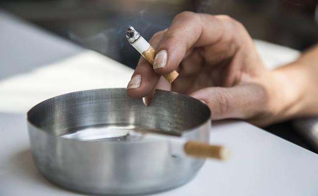 Una persona fuma un cigarro en un bar./J.M. Rodríguez