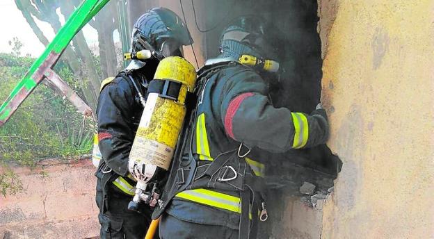 Dos bomberos apagan el incendio en un garaje de Galifa./A.C.