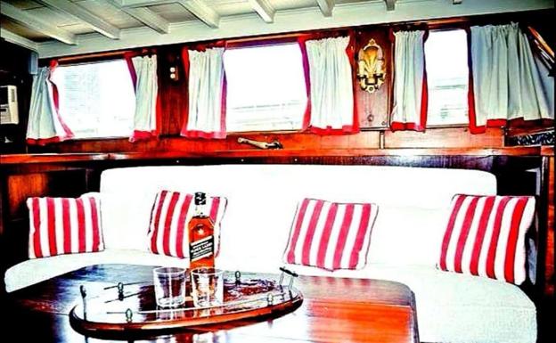 El salón cuenta con un sofá capitoné y grandes ventanales.