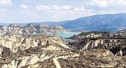 Vista de los barrancos de Gebas desde el mirador; al frente, el camino por el que se accede a la cola del embalse de Algeciras, con sus aguas azul turquesa, que contrastan con el árido paisaje./