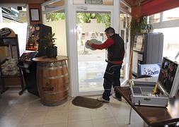 Un cristalero arregla las lunas de la puerta de entrada del bar Plaza Jardín :: Foto: Guillermo Carrión / AGM | Vídeo: laverdad.es/