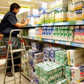 SUBIDAS. Un empleado coloca envases de leche en las estanterías de un supermercado. / M. ATRO./