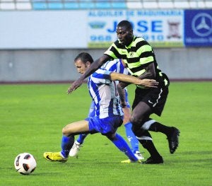 Un jugador del Hércules acosa a un rival del Lorca Atlético en el partido de anoche. :: SONIA M. LARIO / AGM/