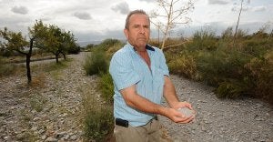 José Sánchez muestra un puñado de tierra en la zona de su finca que dice tener abandonada por la contaminación de aguas residuales del polígono. :: PACO ALONSO / AGM/