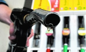 Un usuario sostinene el surtidor de gasolina de una estación de servicio. :: AFP/