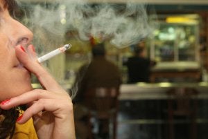 Una mujer fuma en la puerta de un bar de Murcia. :: EDU BOTELLA/