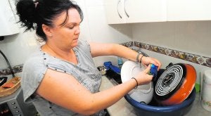 Judith Rodríguez, en la cocina de su casa del polígono de La Paz, fregando los cacharros. Le cortaron el agua, pero pagó los recibos con la ayuda de Cáritas. :: ISRAEL SÁNCHEZ / AGM/