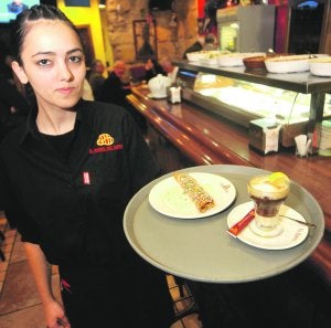 Una camarera de El Barril del Tapeo con una tapa y un asiático. :: A. GIL / AGM/