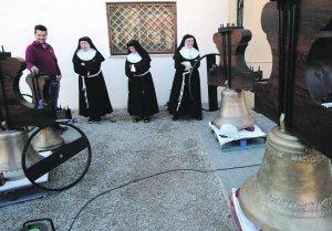 Uno de los restauradores muestra las campanas a la Madre María Jesús, Sor Clara María y Sor Rosario, antes de instalarlas. :: P. A. / AGM/