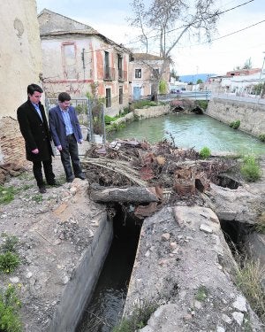 El presidente y el portavoz Huermur, Sergio Pacheco y Pedro Jesús Fernández, respectivamente, ayer, frente a restos de poda sobre las ruinas del molino de las Cuatro Piedras de La Arboleja. :: V. VICÉNS/AGM/