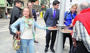 La concejal Ana Martínez (d) prueba el funcionamiento de la farola-cargador. :: A. DURÁN/AGM/
