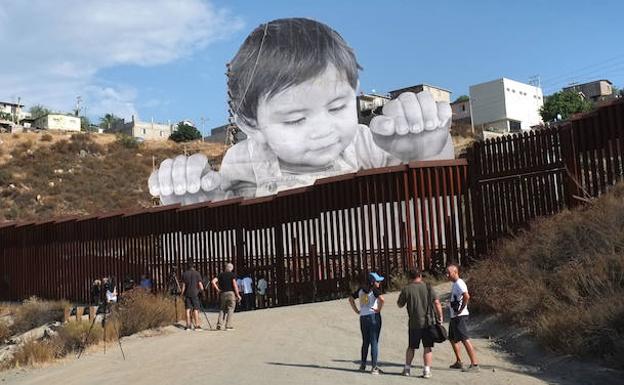 Un artista instala un niño gigante en la frontera de EE UU y México