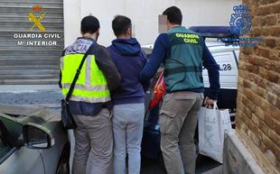 Uno de los detenidos custodiado por la Policía Nacional y la Guardia Civil./D. G.