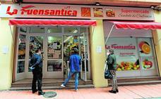 Tres vecinos esperan su turno para acceder a un supermercado en la calle Cánovas del Castillo, en Murcia, ayer por la mañana./EDU BOTELLA / AGM