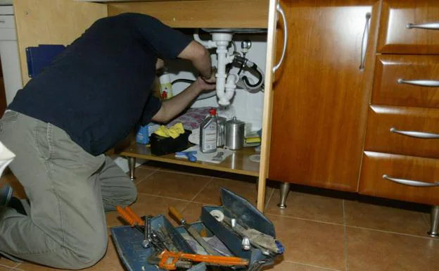 Stock image of a plumber repairing a fault. 