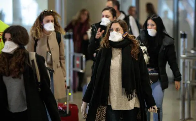 Several women walk through an airport. 