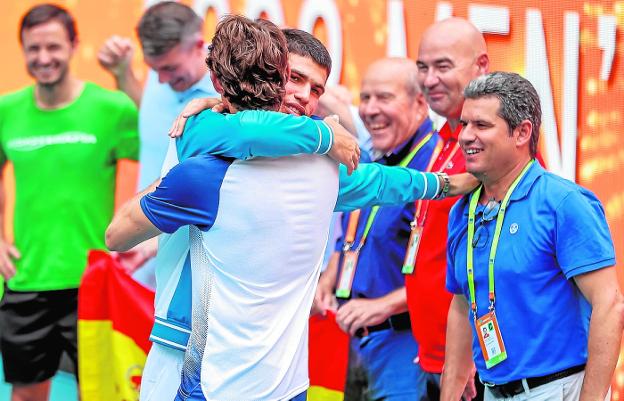 Alcaraz hugs Ferrero, in the presence of his father, on the right, at the award ceremony. 