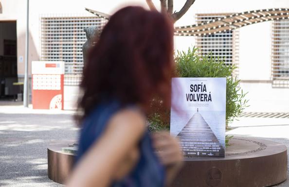A woman looks at the promotional poster for 'Sofia will return'.