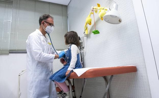 A pediatrician treats a girl in a file image.