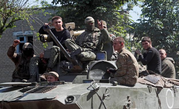 Service members of the pro-Russian troops travel in an armored vehicle in the town of Popasna (Lugansk).