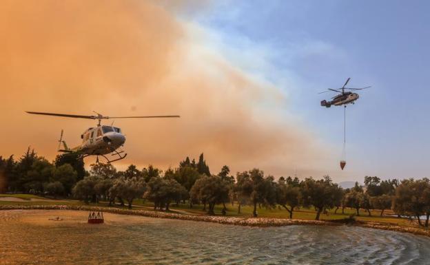 Helicopters supply themselves with water to launch on the flames of the Mijas fire. 